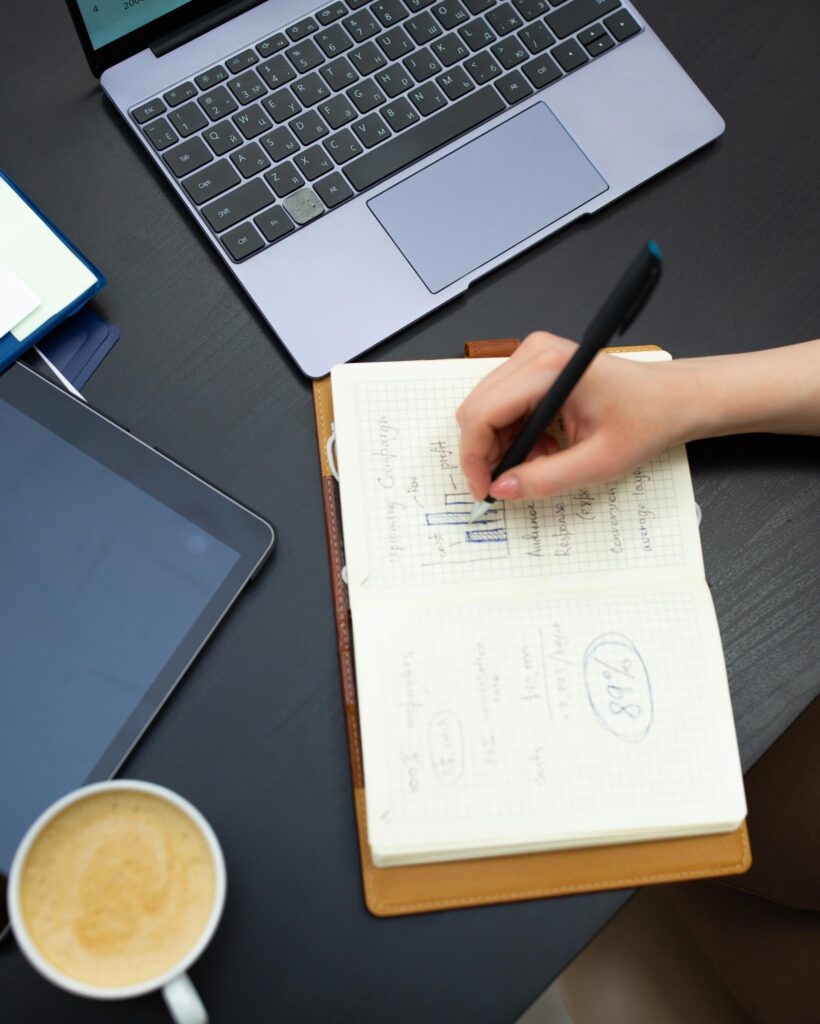 Person analyzing SaaS SEO data in notebook beside laptop